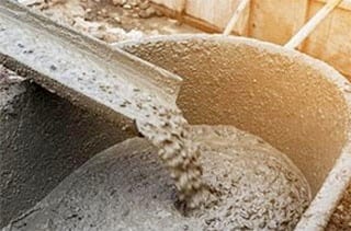 wet cement being poured into a wheelbarrow
